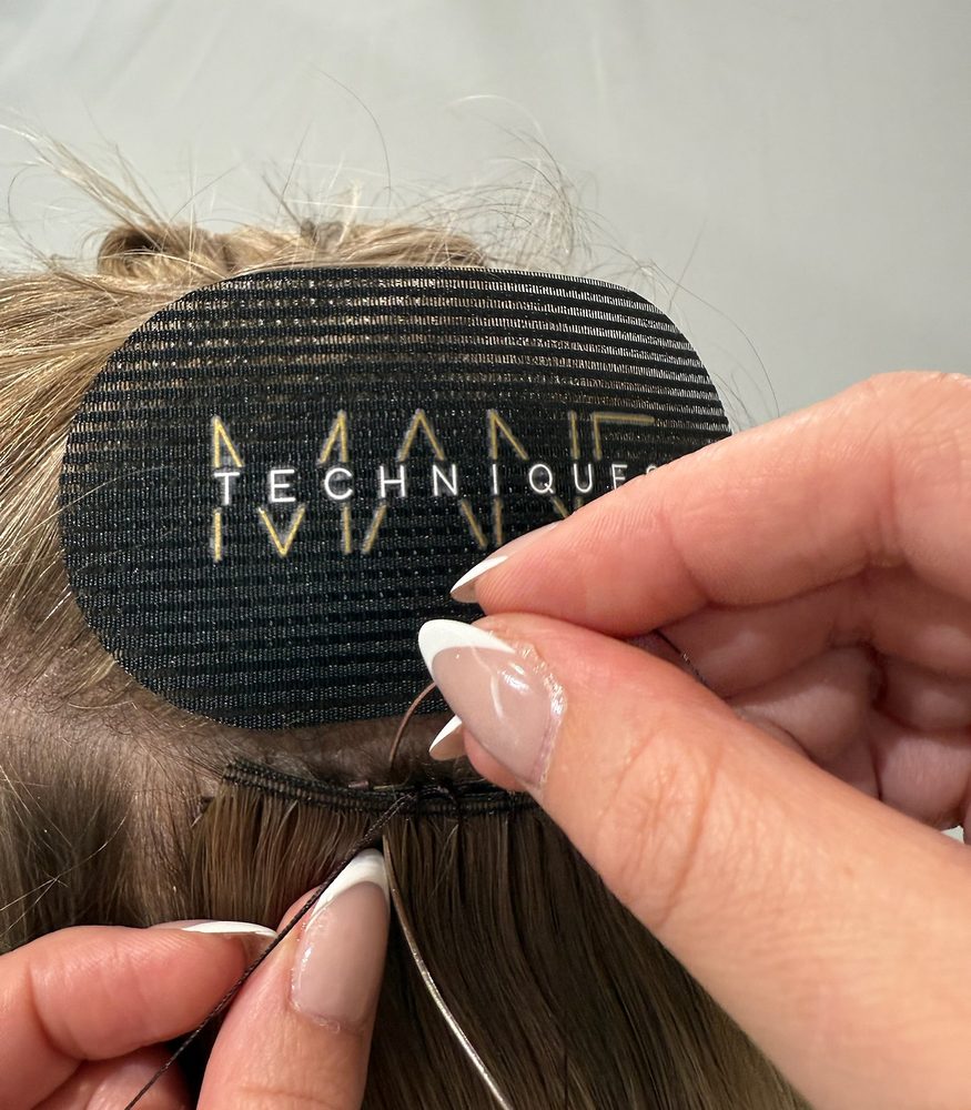 Hand holding a Mane Techniques extension weft